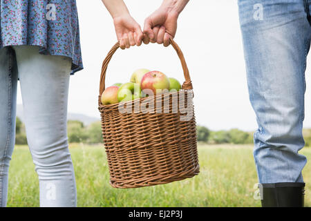 Giovane Azienda cesto pieno di mele Foto Stock