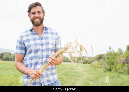 Felice l'uomo con il suo un covone di grano Foto Stock