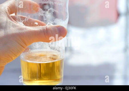 Maschio di mano in mano un bicchiere di birra Foto Stock