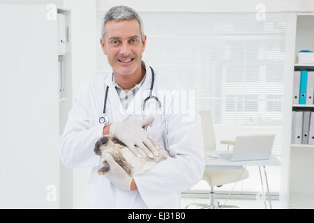 Vet sorridente con un coniglio nelle sue braccia Foto Stock