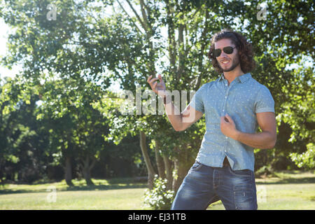 Giovane uomo suonare la chitarra di aria nel parco Foto Stock