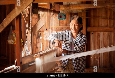 Anziana donna birmano di tessitura della seta lotus al suo telaio, Paw Khone village, Lago Inle, Myanmar ( Birmania ), Asia Foto Stock