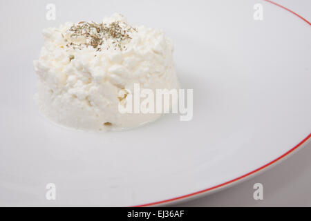 Granulati per la ricotta con erbe aromatiche. Isolato su bianco Foto Stock