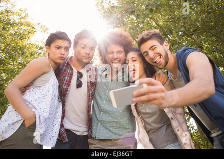 Happy amici nel parco tenendo selfie Foto Stock