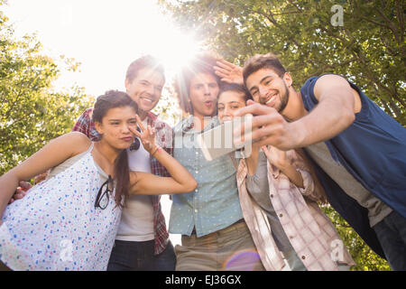 Happy amici nel parco tenendo selfie Foto Stock
