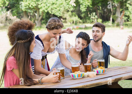 Bella ragazza oktoberfest che servono gli amici Foto Stock