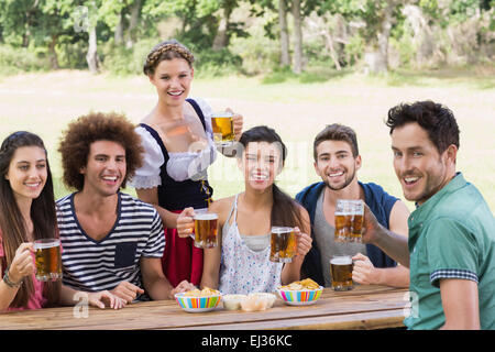 Bella ragazza oktoberfest che servono gli amici Foto Stock