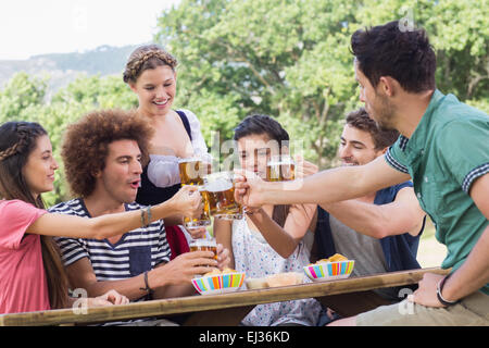 Bella ragazza oktoberfest che servono gli amici Foto Stock