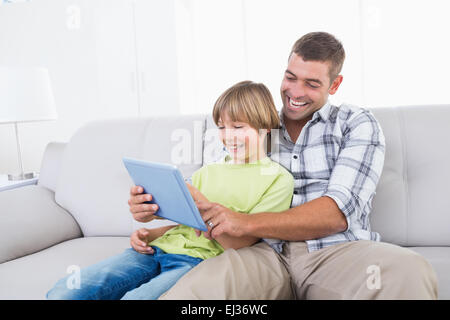 Padre e figlio giocando sulla tavoletta digitale Foto Stock