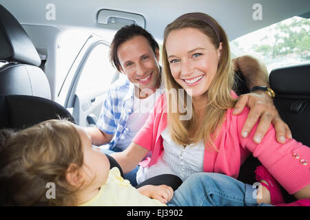 I genitori che fissano il bambino nel seggiolino per auto Foto Stock