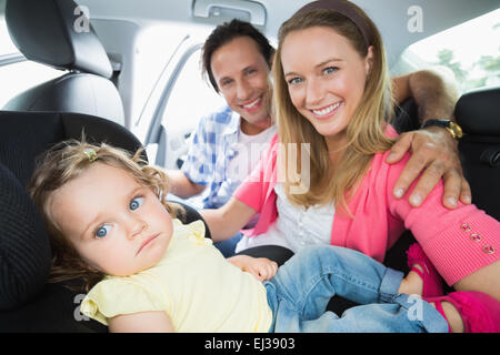 I genitori che fissano il bambino nel seggiolino per auto Foto Stock