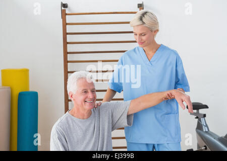 Senior uomo stretching con il suo terapista Foto Stock