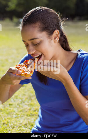 Pretty Woman mangiare la pizza nel parco Foto Stock