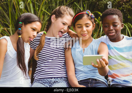 Dei bambini felici prendendo selfie presso il park Foto Stock