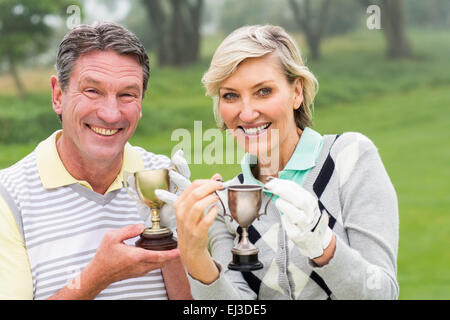 Felice coppia di golf con il trofeo Foto Stock