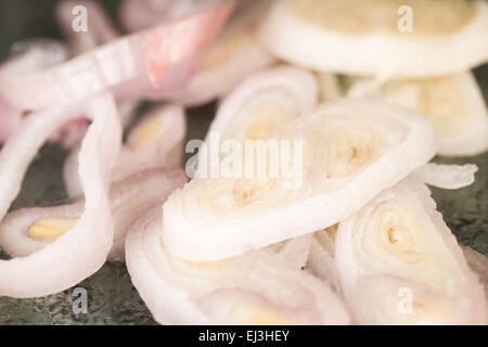 Sottili fette di scalogni che sono ora pronti per essere saltati come condimento per un veggie pizza. Foto Stock