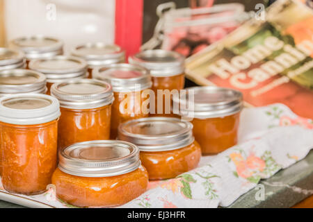 Vasi di fresca di marmellata di albicocche fatta in casa il raffreddamento su un canovaccio senza toccare o spostando in un progetto-posto libero Foto Stock