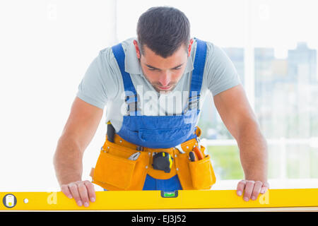 Carpenter utilizzando la livella in office Foto Stock