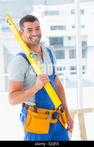 Felice repairman in tuta mantenendo la livella in office Foto Stock