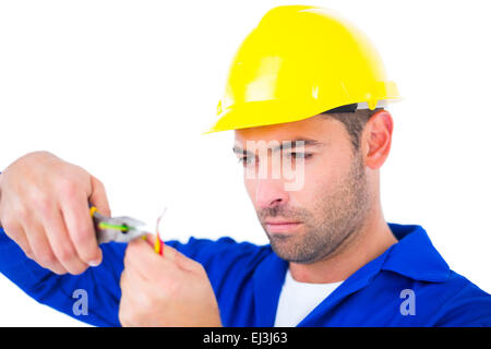 Elettricista indossare elmetto mentre il filo di taglio Foto Stock