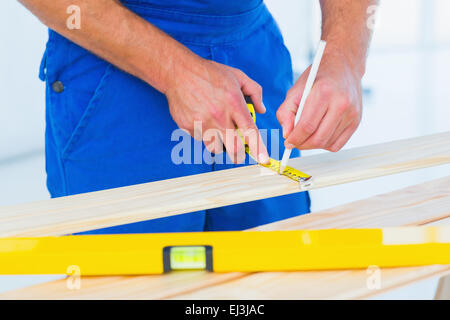 Carpenter marcatura sul listone con nastro di misurazione Foto Stock