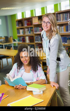 Studente ottenere aiuto dal tutor in biblioteca Foto Stock