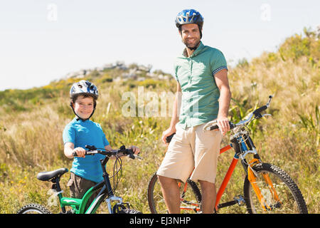 Padre e figlio in bici attraverso le montagne Foto Stock