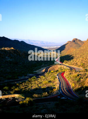 La strada a cancelli passano nelle montagne di Tucson si illumina al buio con la città di Tucson e a distanza Foto Stock