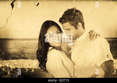 Immagine composita della coppia giovane abbracciando e in posa sulla spiaggia Foto Stock