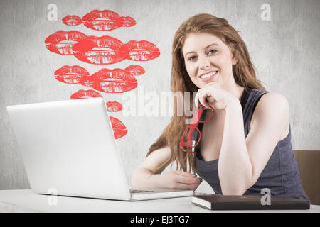 Immagine composita di pretty redhead lavorando sul computer portatile Foto Stock