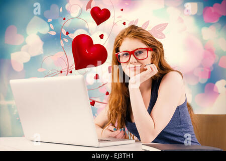 Immagine composita di pretty redhead lavorando sul computer portatile Foto Stock