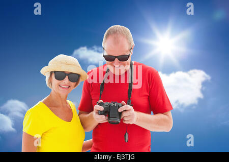 Immagine composita di felice coppia matura indossando occhiali da sole Foto Stock