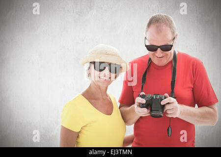 Immagine composita di felice coppia matura indossando occhiali da sole Foto Stock