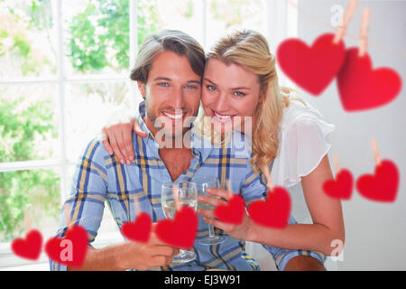 Immagine composita di carino coppia sorridente godendo il vino bianco insieme Foto Stock