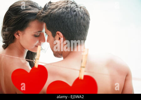 Immagine composita della coppia attraente seduti a bordo piscina sorridente Foto Stock