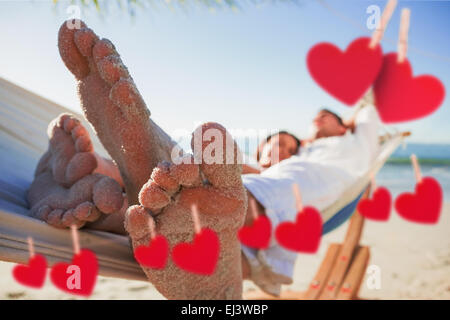 Immagine composita di close up di sandy piedi di coppia in un amaca Foto Stock