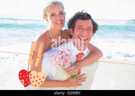 Immagine composita di bello groom dando la sua nuova moglie una piggy back Foto Stock