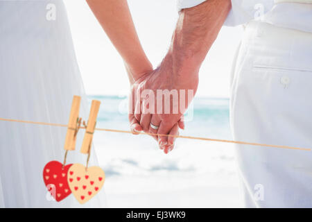 Immagine composita della sposa e lo sposo holding hands close up Foto Stock