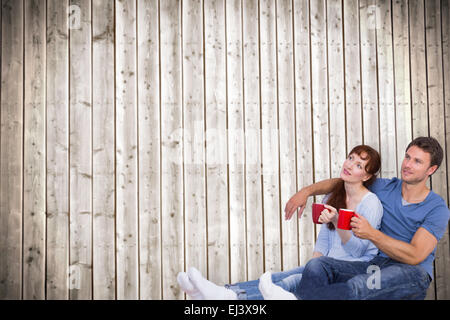 Immagine composita della giovane avente il tè sul pavimento Foto Stock