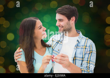 Immagine composita di felice coppia giovane azienda nuova chiave di casa Foto Stock
