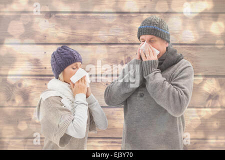 Immagine composita di malati coppia matura soffia il naso Foto Stock