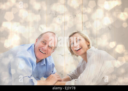 Immagine composita della coppia matura giacenti e sorridente Foto Stock