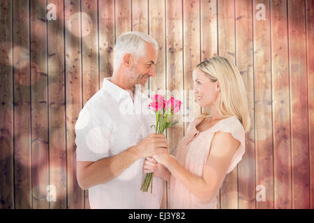 Immagine composita di affettuosa uomo offrendo il suo partner rose Foto Stock