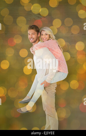 Immagine composita di uomo bello dando piggy back alla sua ragazza Foto Stock