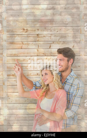 Immagine composita di attraente coppia giovane abbracciando e puntamento Foto Stock