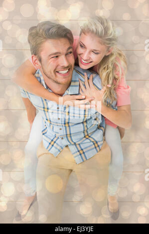 Immagine composita di uomo bello dando piggy back alla sua ragazza Foto Stock
