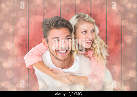 Immagine composita di uomo bello dando piggy back alla sua ragazza Foto Stock