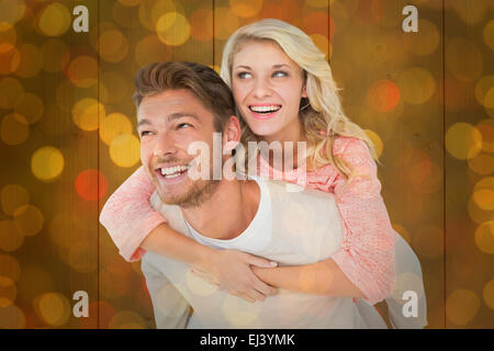 Immagine composita di uomo bello dando piggy back alla sua ragazza Foto Stock