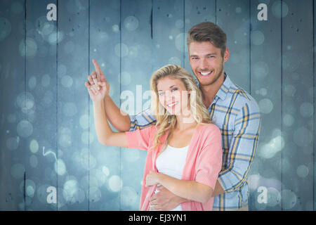 Immagine composita di attraente coppia giovane abbracciando e puntamento Foto Stock