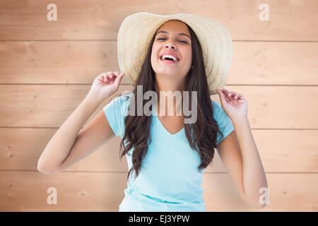 Immagine composita di felice giovani brunette indossando cappello Foto Stock